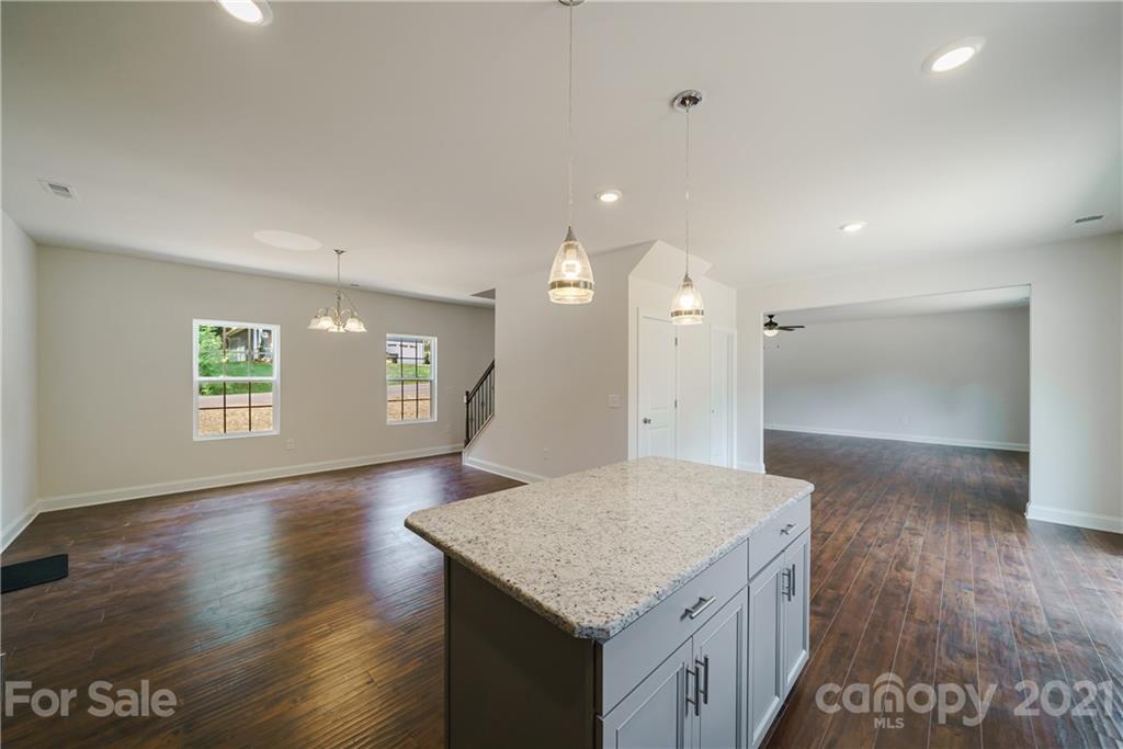 1802 Love Road Monroe, NC 28110 - Photo 12 of 48 an empty room with wooden floor and a kitchen