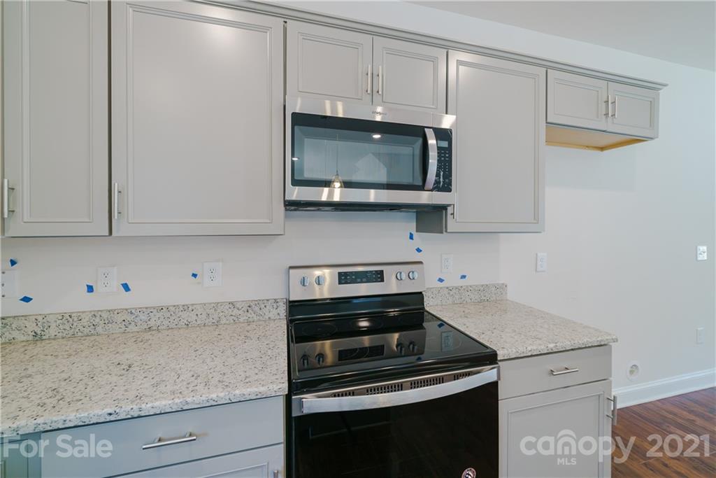 1802 Love Road Monroe, NC 28110 - Photo 13 of 48 a kitchen with stainless steel appliances granite countertop white cabinets and a stove top oven