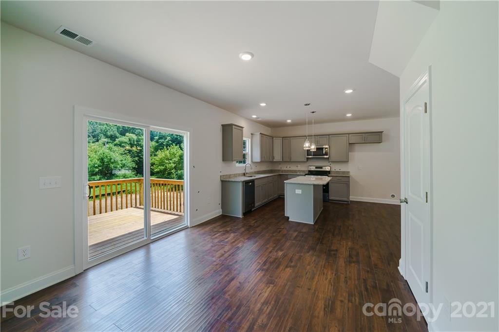 1802 Love Road Monroe, NC 28110 - Photo 17 of 48 a kitchen with stainless steel appliances granite countertop a stove top oven a sink with wooden floors and view living room