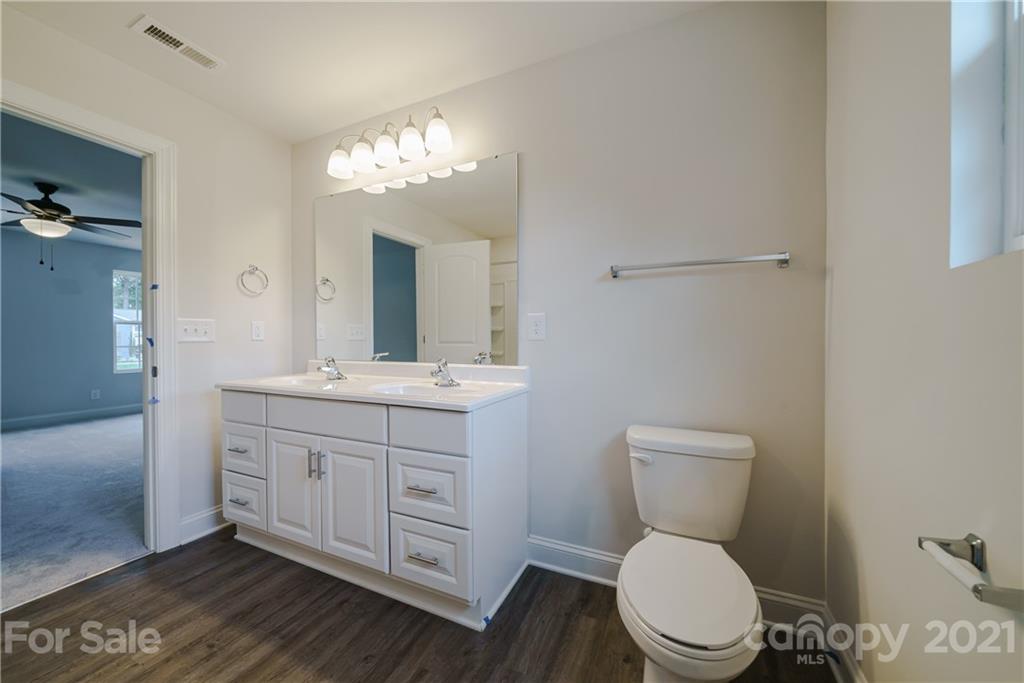 1802 Love Road Monroe, NC 28110 - Photo 35 of 48 a bathroom with a toilet a sink and a large mirror