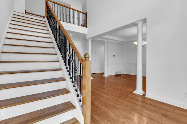 a view of staircase with wooden floor and white walls