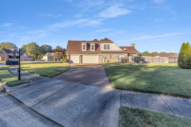 a view of a big house with a big yard and large trees