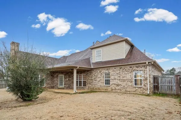 a large kitchen with stainless steel appliances a sink a counter top space cabinets and a wooden floor
