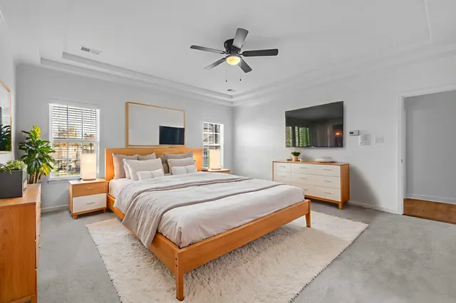 a bedroom with bed couches and a flat tv screen