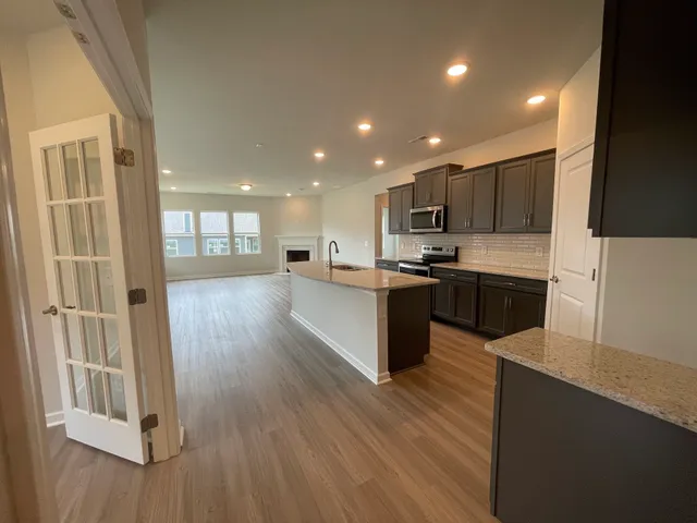 a large kitchen with stainless steel appliances lots of counter top space and wooden floor