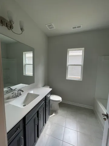a bathroom with a sink toilet and window