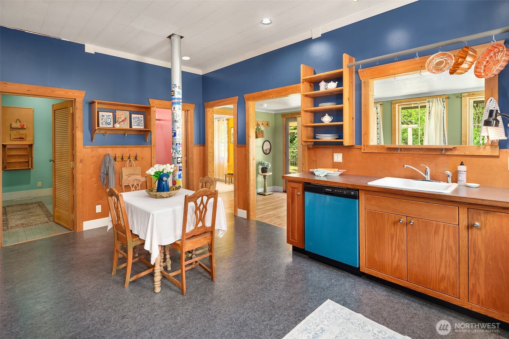 19416 Beall Road Southwest Vashon, WA 98070 - Photo 9 of 40 a dining hall with stainless steel appliances granite countertop a sink a stove a dining table and chairs with wooden floor