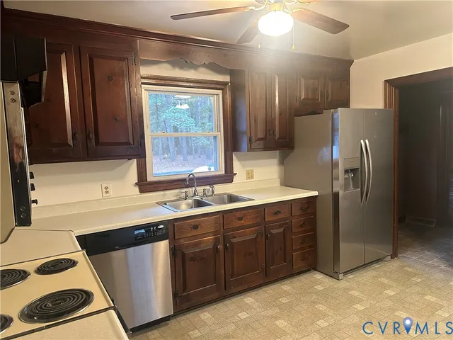 a kitchen with a sink a refrigerator and cabinets