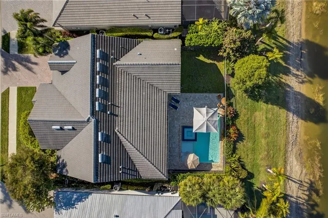 an aerial view of a house with a yard potted plants and large tree
