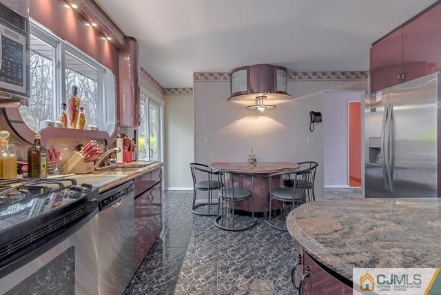 22 Kings Road East Brunswick, NJ 08816 - Photo 11 of 24 a kitchen with stainless steel appliances kitchen island granite countertop a table chairs in it and wooden floors