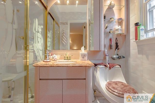 22 Kings Road East Brunswick, NJ 08816 - Photo 18 of 24 a bathroom with a granite countertop sink a toilet and a mirror
