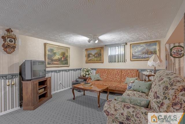 22 Kings Road East Brunswick, NJ 08816 - Photo 20 of 24 a living room with furniture a flat screen tv and a window