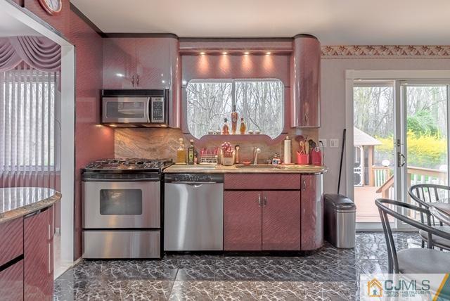 22 Kings Road East Brunswick, NJ 08816 - Photo 7 of 24 a kitchen with granite countertop a stove and a wooden cabinets