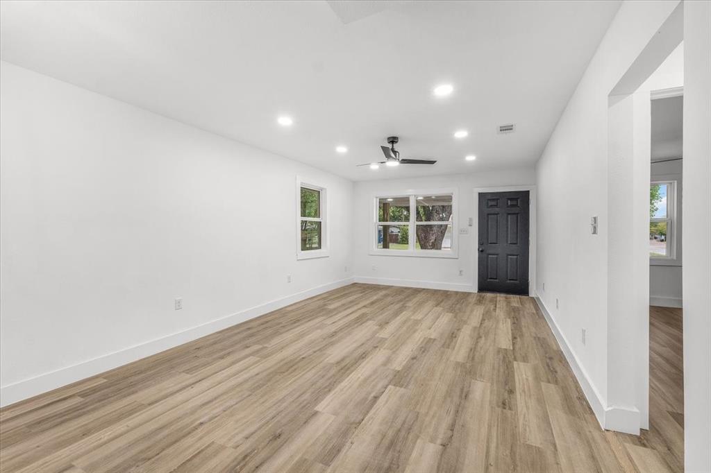 3301 Hedrick Street Fort Worth, TX 76111 - Photo 5 of 22 a view of an empty room with wooden floor and a window