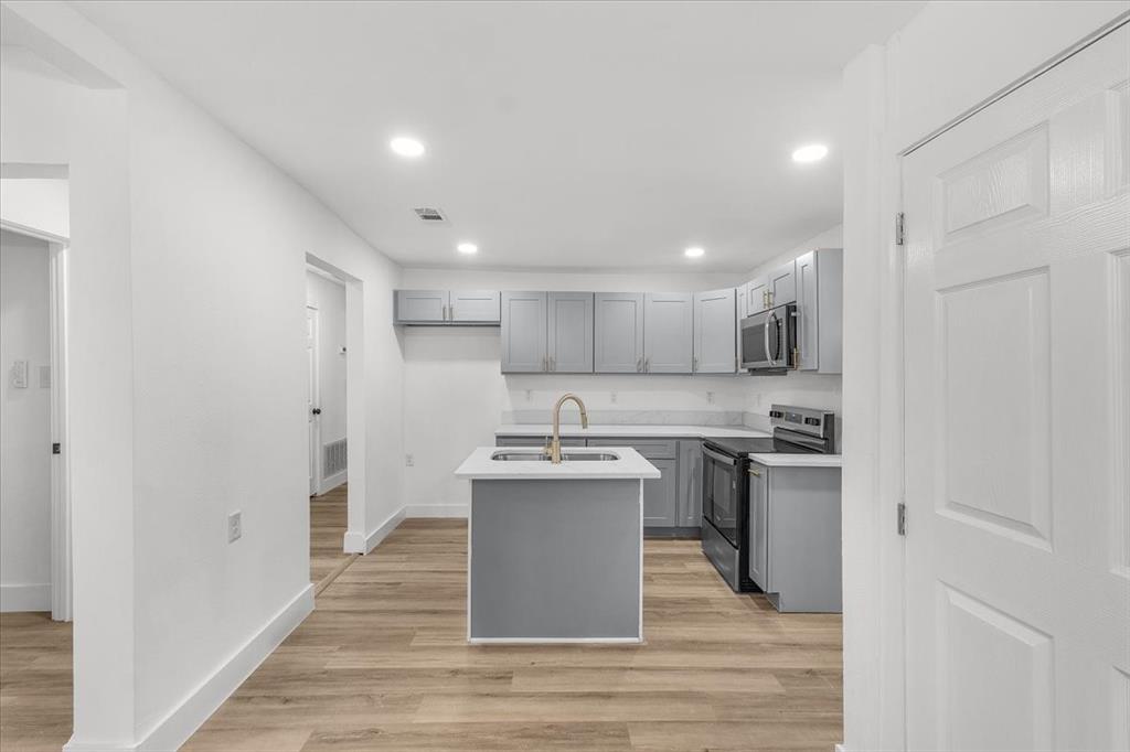 3301 Hedrick Street Fort Worth, TX 76111 - Photo 7 of 22 a kitchen with stainless steel appliances granite countertop a sink stove and refrigerator