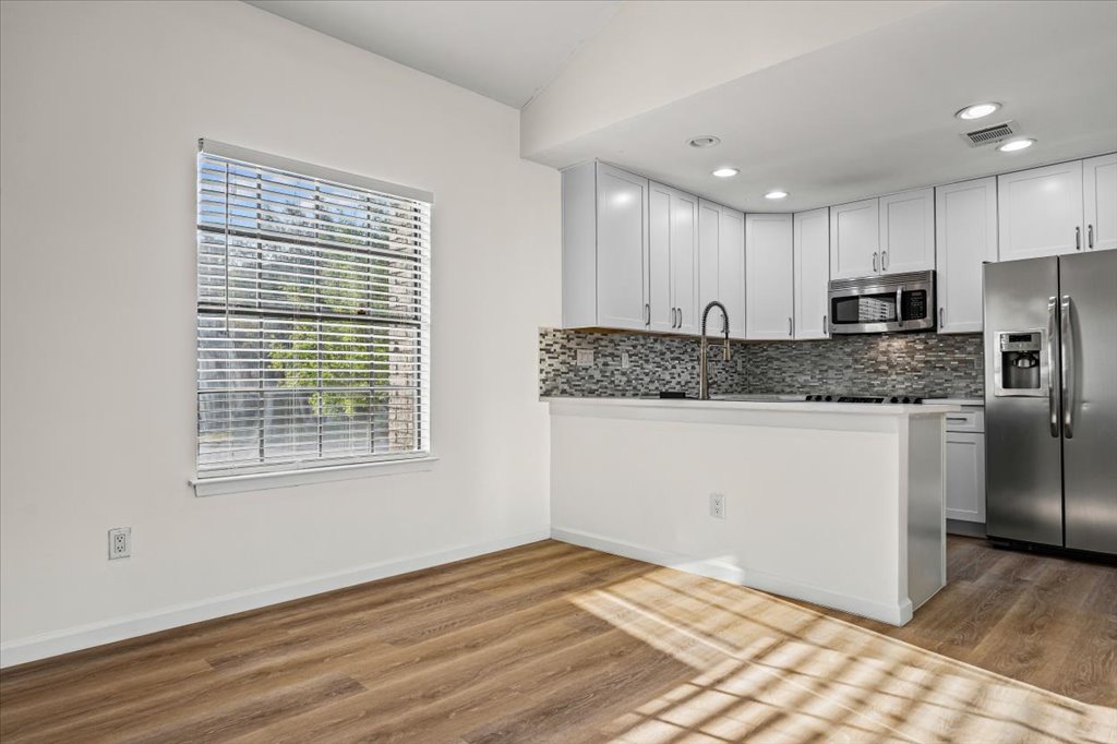 1748 Ohlen Road, Unit 75 Austin, TX 78757 - Photo 15 of 33 Kitchen with stainless steel appliances, white cabinetry, tasteful backsplash, light wood-type flooring, and recessed lighting