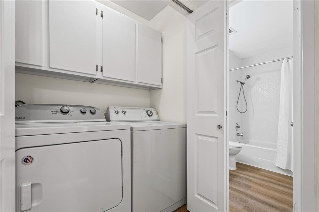 1748 Ohlen Road, Unit 75 Austin, TX 78757 - Photo 20 of 33 Laundry area featuring light wood-style flooring, washing machine and clothes dryer, and cabinet space