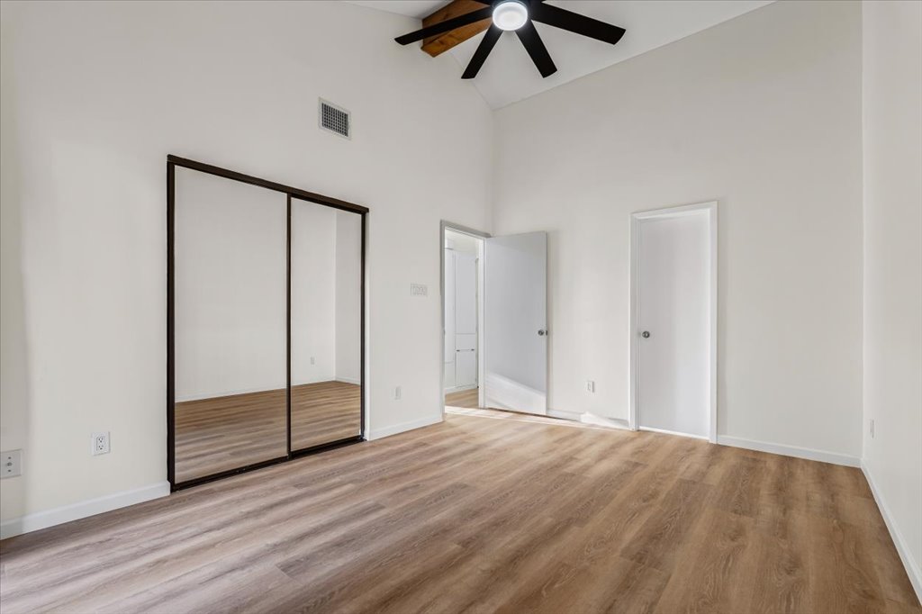 1748 Ohlen Road, Unit 75 Austin, TX 78757 - Photo 23 of 33 Unfurnished bedroom with high vaulted ceiling, light wood finished floors, and a ceiling fan
