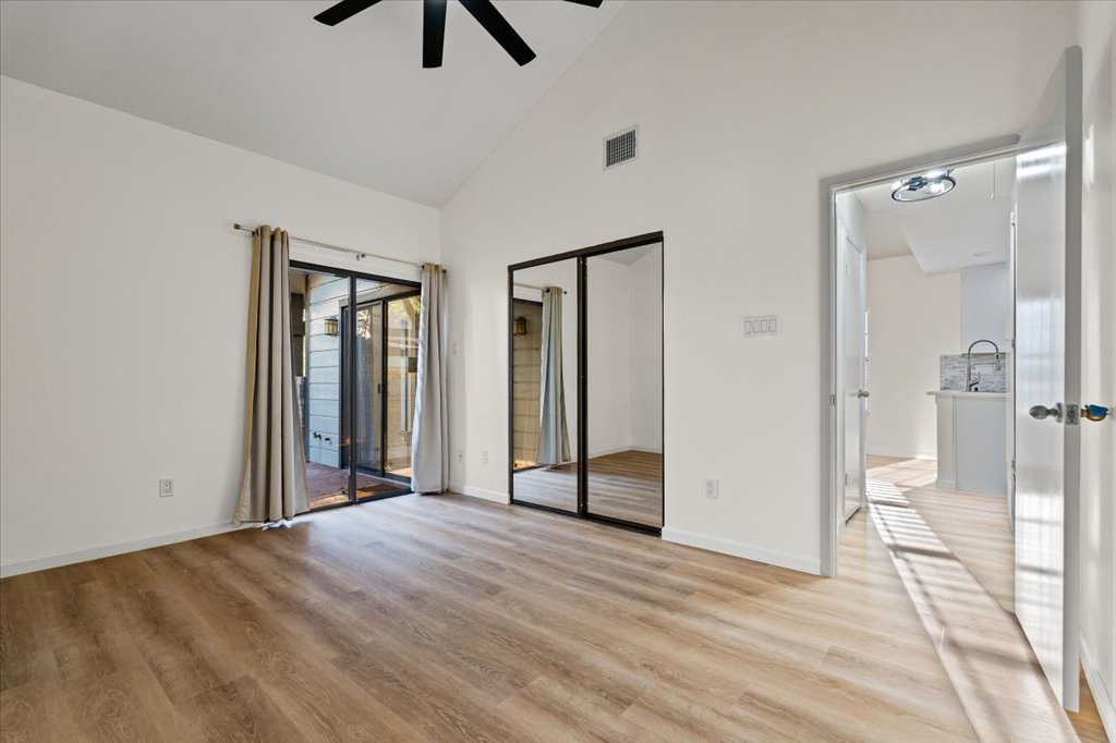 1748 Ohlen Road, Unit 75 Austin, TX 78757 - Photo 24 of 33 Unfurnished bedroom featuring high vaulted ceiling, access to exterior, light wood-style floors, a closet, and ceiling fan