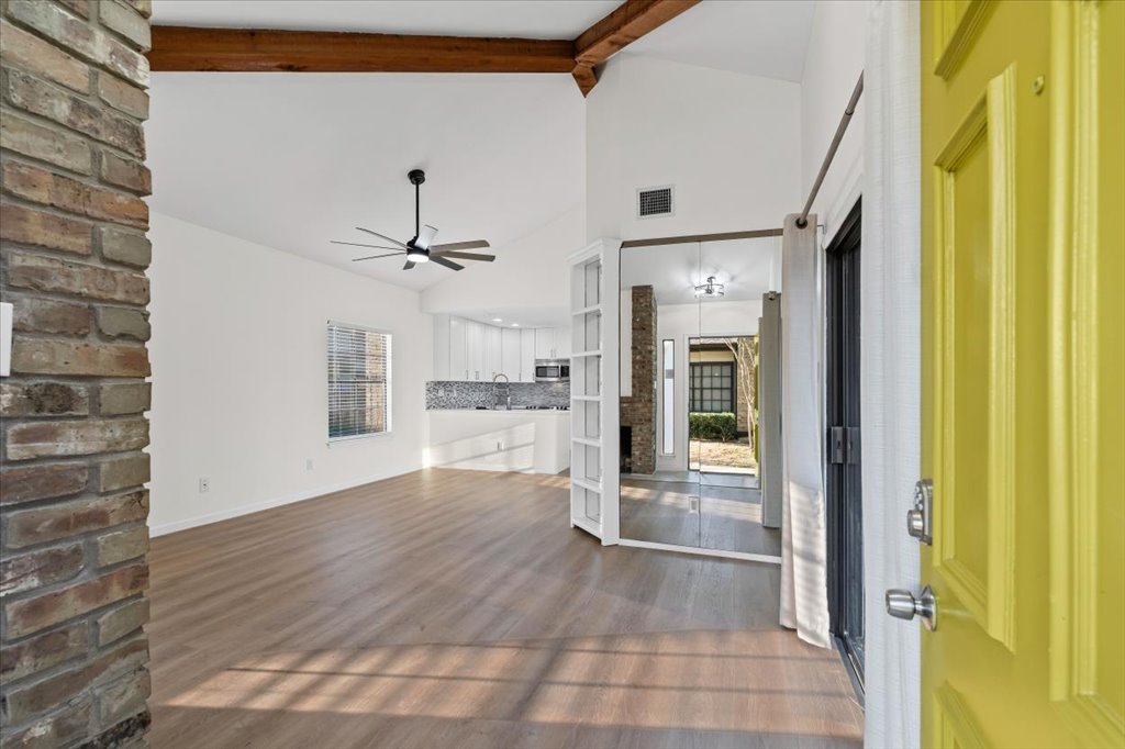 1748 Ohlen Road, Unit 75 Austin, TX 78757 - Photo 3 of 33 Unfurnished living room featuring plenty of natural light, dark wood finished floors, beamed ceiling, high vaulted ceiling, and a ceiling fan