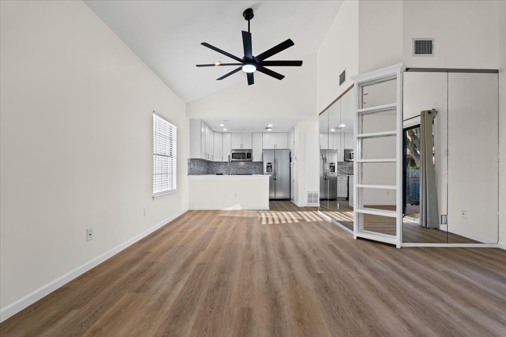 1748 Ohlen Road, Unit 75 Austin, TX 78757 - Photo 4 of 33 Unfurnished living room with high vaulted ceiling, ceiling fan, and light wood-style flooring