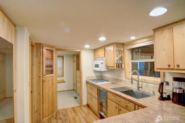 a view of a kitchen with a sink and dishwasher with wooden floor