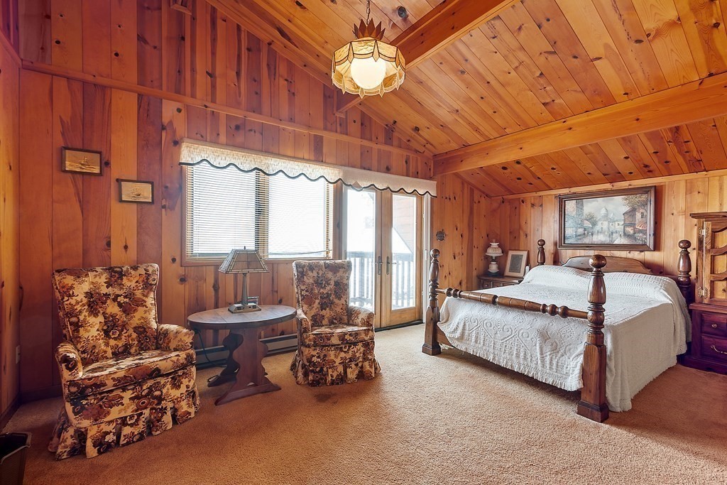 1585 Ocean Boulevard Rye, NH 03870 - Photo 35 of 41 a spacious bedroom with a bed and a chandelier