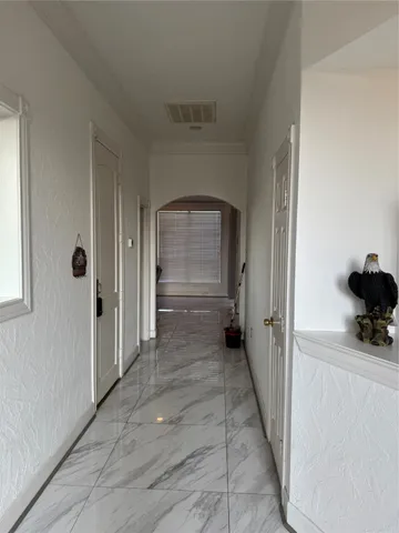 a view of a hallway with wooden floor and a cabinet