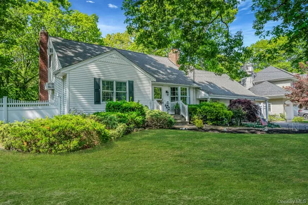 a view of a house with a yard and potted plants