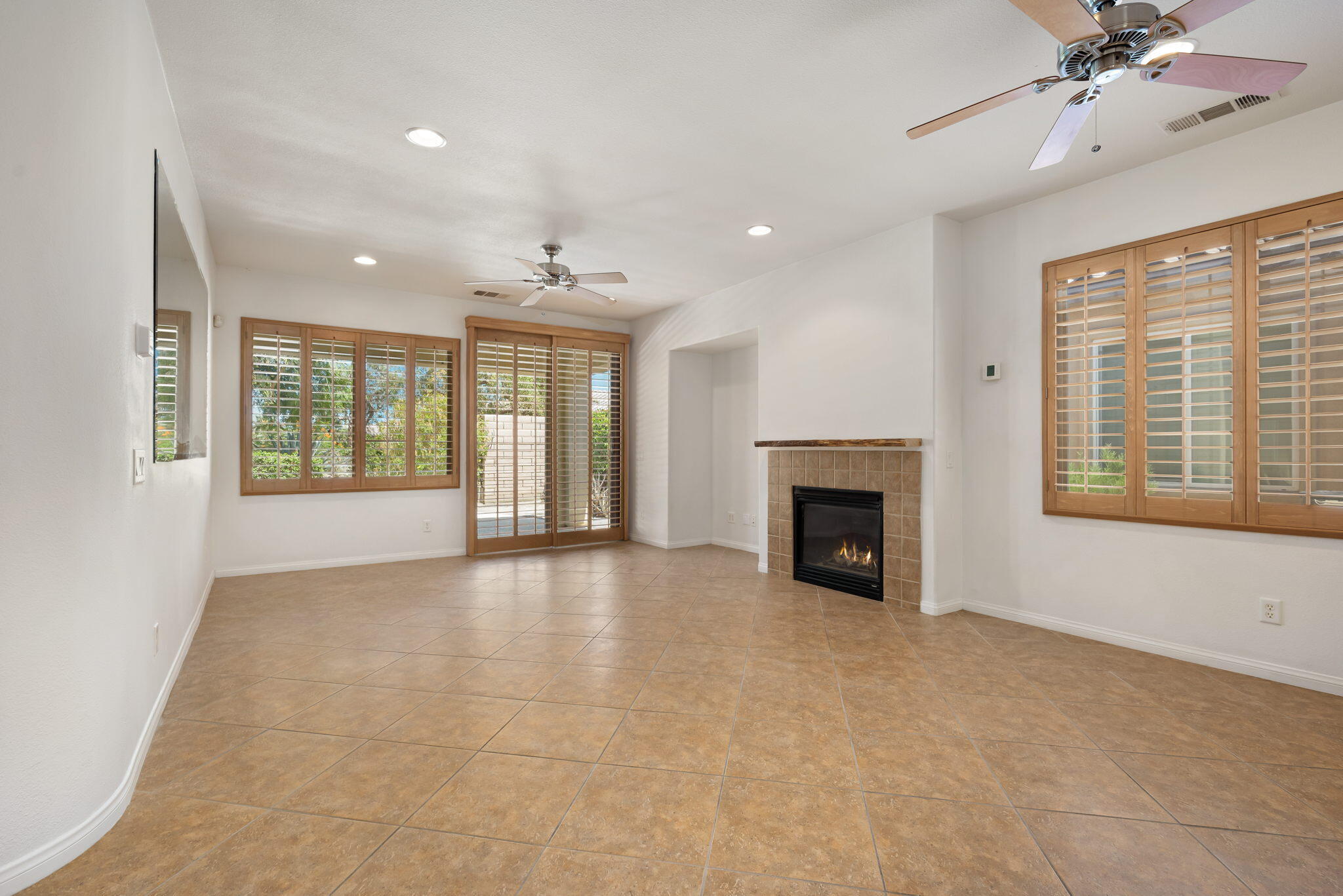 49728 Pacino Street Indio, CA 92201 - Photo 13 of 54 a view of an empty room with a fireplace and a window