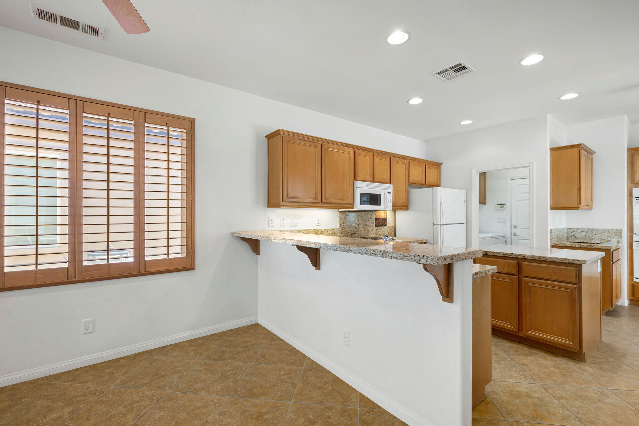 49728 Pacino Street Indio, CA 92201 - Photo 18 of 54 a kitchen with stainless steel appliances granite countertop a sink stove and refrigerator