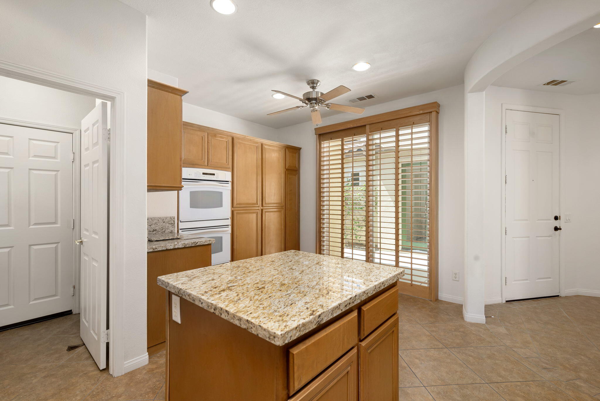 49728 Pacino Street Indio, CA 92201 - Photo 25 of 54 a kitchen with kitchen island granite countertop cabinets and refrigerator