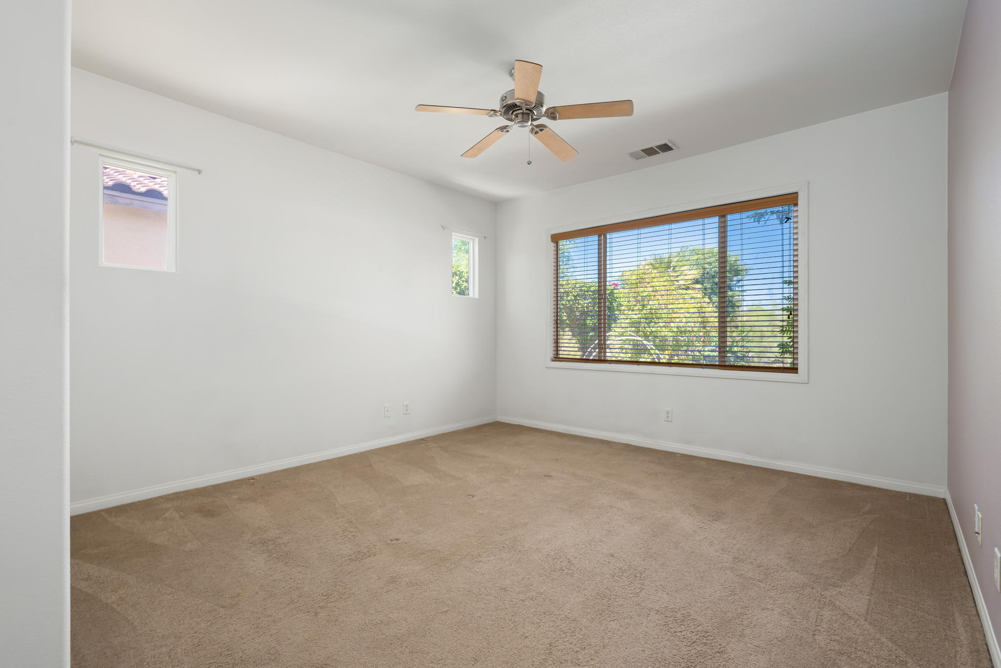 49728 Pacino Street Indio, CA 92201 - Photo 27 of 54 an empty room with windows and ceiling fan