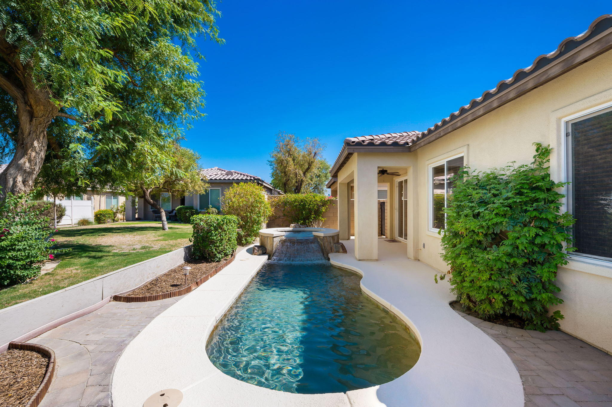 49728 Pacino Street Indio, CA 92201 - Photo 40 of 54 a view of a house with a yard potted plants and a large tree