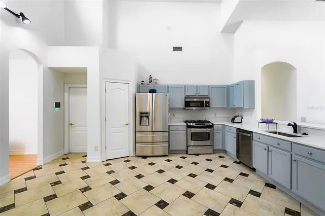 a kitchen with stainless steel appliances a stove a sink and a refrigerator