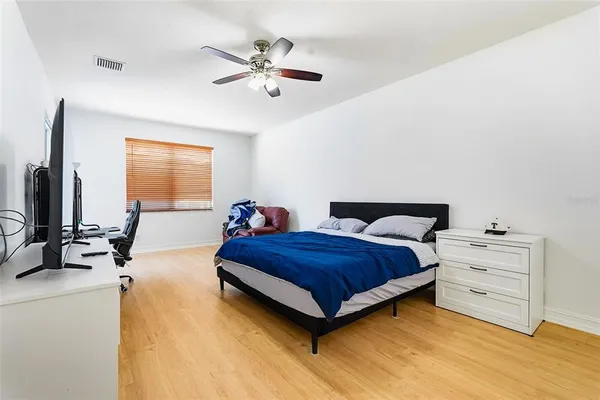 a spacious bedroom with a bed and a chandelier
