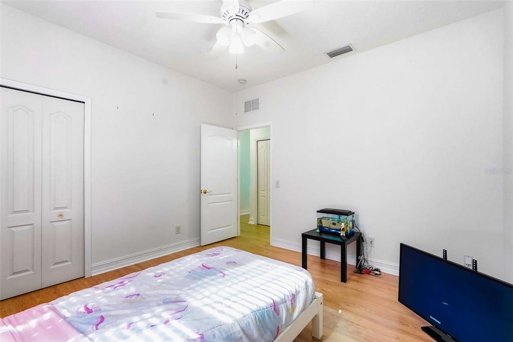 2807 Manning Drive Trinity, FL 34655 - Photo 28 of 48 a bedroom with a bed and a chandelier