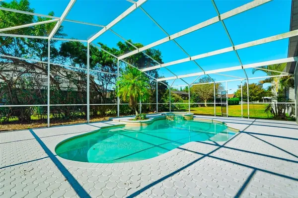 a view of a backyard with swimming pool and yard