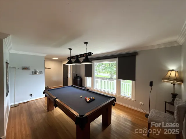 a living room with pool table and a window