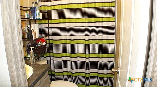 a kitchen with granite countertop a refrigerator a stove a sink and a window