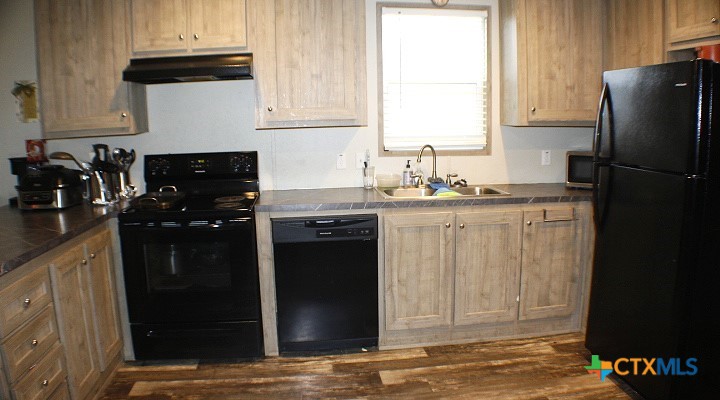 12240 Fm 1383 Schulenburg, TX 78956 - Photo 15 of 24 a kitchen with granite countertop a refrigerator a stove a sink and a window