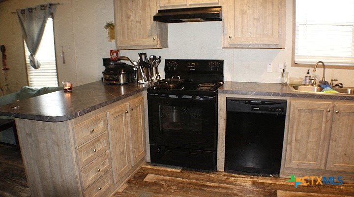 12240 Fm 1383 Schulenburg, TX 78956 - Photo 16 of 24 a kitchen with stainless steel appliances granite countertop a stove a sink and a refrigerator