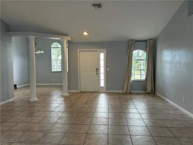 a view of an empty room with window and bathroom