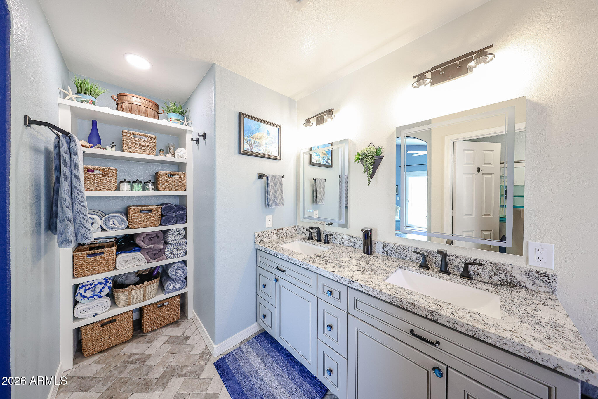 6939 West Phelps Road Peoria, AZ 85382 - Photo 16 of 29 a en suite bathroom with double vanity a mirror and a double vanity sink
