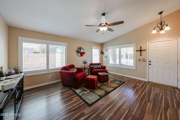 a living room with furniture two window and wooden floor