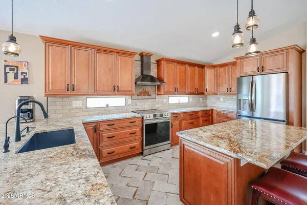 a kitchen with stainless steel appliances granite countertop a stove refrigerator sink and cabinets