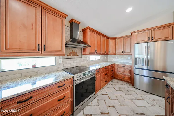 a kitchen with stainless steel appliances granite countertop a refrigerator sink and cabinets
