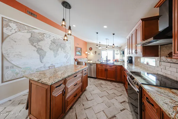 a kitchen with stainless steel appliances granite countertop a sink counter space and a stove