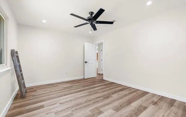 a view of room with wooden floor and ceiling fan