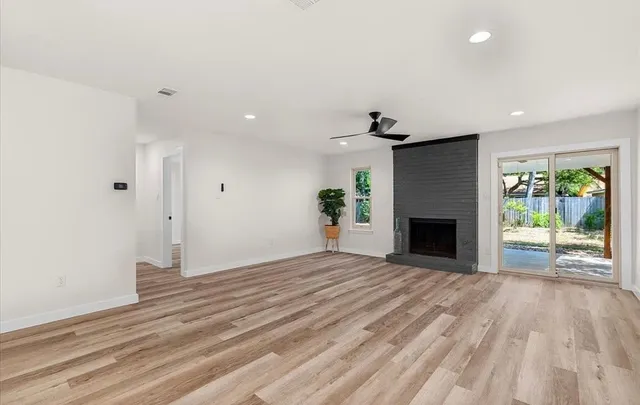 a view of empty room with wooden floor and fireplace